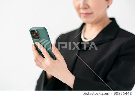 Women in mourning dress smartphone funeral 90855448