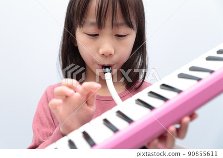 Girl playing keyboard harmonica Girl playing keyboard harmonica 90855611