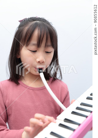 Girl playing keyboard harmonica 90855612