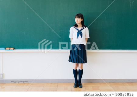 School girls standing in front of the blackboard 90855952