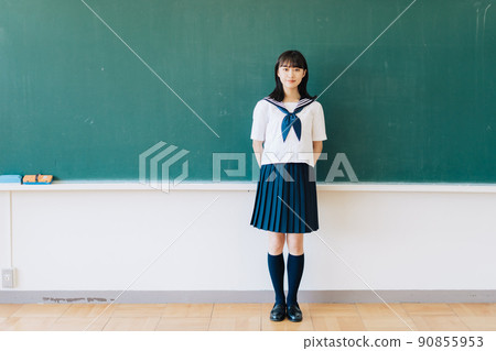 School girls standing in front of the blackboard 90855953