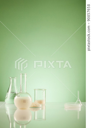 Front view of scientist working with chemical reaction in chemistry laboratory rice in transparent test tube and green blackground with blank space for advertising 90857658