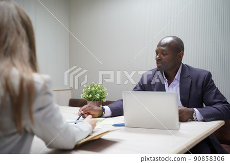 Image of young businessmen and colleague discussing document in laptop and touchpad at meeting 90858306