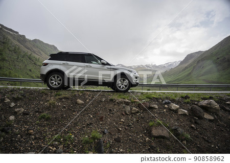 Range Rover Evoque car on the background of the mountains of the North Caucasus in Russia. Cloudy day on June 5, 2022 90858962