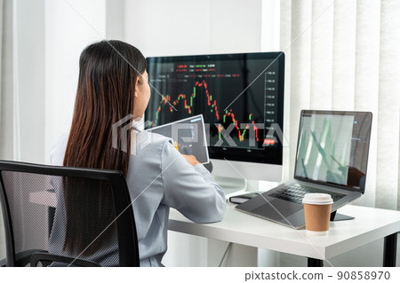 Businesswoman investor working with computer, tablet and analyzing graph stock market trading planning with chart data financial investment planning 90858970