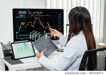 Businesswoman investor working with computer, tablet and analyzing graph stock market trading planning with chart data financial investment planning 90858971