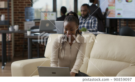 African american worker analyzing business charts and financial statistics on laptop to plan development. Female employee creating marketing presentation online on computer in office. 90859097