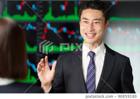 Business person having a conversation in front of the chart screen 90859180