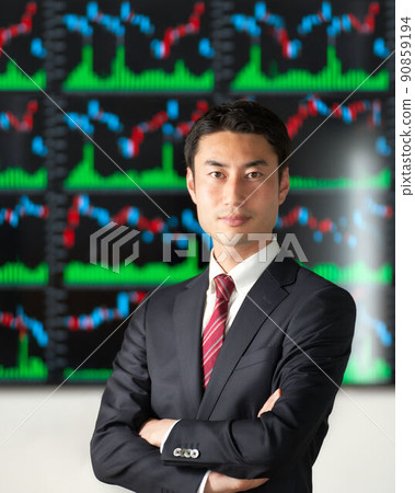 A business person in a suit with his arms crossed in front of the chart screen A business person in a suit with his arms crossed in front of the chart screen 90859194