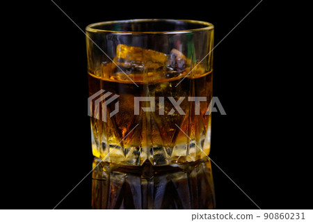Glass of whiskey with ice on a black background Glass of whiskey with ice on a black background 90860231