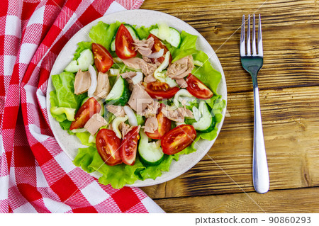 Tasty tuna salad with lettuce and fresh vegetables on wooden table. Top view 90860293