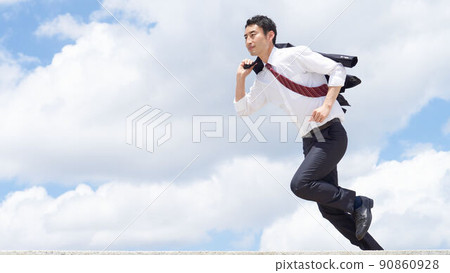 A business person running with a jacket over his shoulder under the blue sky 90860928