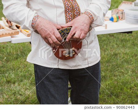 Musician plying mbira ethnic musical instrument. Lamellophone, Plucked Idiophone. Folk music festival Lviv, Ukraine. 90862443
