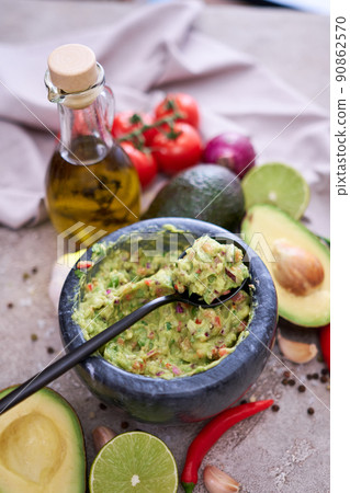 freshly made guacamole in marble mortar with ingredients on grey concrete background 90862570