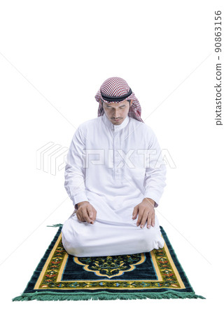 Muslim man with keffiyeh with agal in praying position (salat) on the prayer rug Muslim man with keffiyeh with agal in praying position (salat) on the prayer rug 90863156
