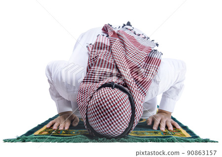 Muslim man with keffiyeh with agal in praying position (salat) on the prayer rug Muslim man with keffiyeh with agal in praying position (salat) on the prayer rug 90863157