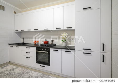 Trendy white modern kitchen interior with minimalistic furniture Trendy white modern kitchen interior with minimalistic furniture 90864065