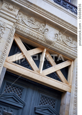 Wooden door and support beams of a French mansion Wooden door and support beams of a French mansion 90868656