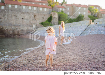 Mother and two children daughter and son tourists on background of beautiful view St. Stephen island, Sveti Stefan on the Budva Riviera, Budva, Montenegro. Travel to Montenegro concept 90868963
