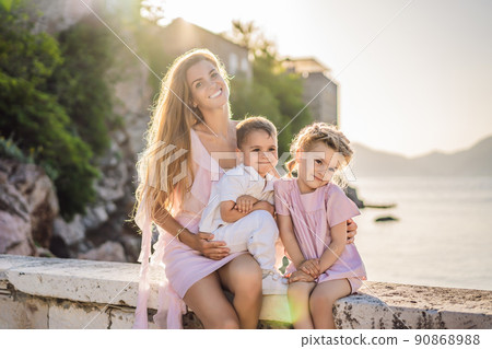 Mother and two children daughter and son tourists on background of beautiful view St. Stephen island, Sveti Stefan on the Budva Riviera, Budva, Montenegro. Travel to Montenegro concept Mother and two children daughter and son tourists on background of beautiful view St. Stephen island, Sveti Stefan on the Budva Riviera, Budva, Montenegro. Travel to Montenegro concept 90868988