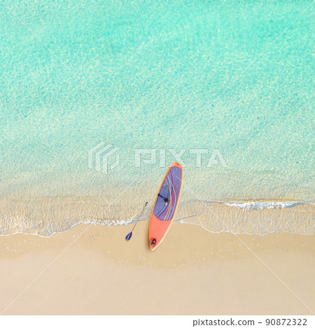 Top view of tropical Seychelles sand beach with SUP board for surfing on the shore. Blue, turquoise transparent water surface of ocean, sea, lagoon. Horizontal background. Aerial, drone view 90872322