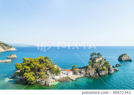 The island of Panagia with church located right in front of the port of Parga among in blue, turquoise sea water. Aerial, top, drone view. Greece 90872342