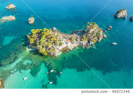 The island of Panagia with church located right in front of the port of Parga among in blue, turquoise sea water. Aerial, top, drone view. Greece 90872346