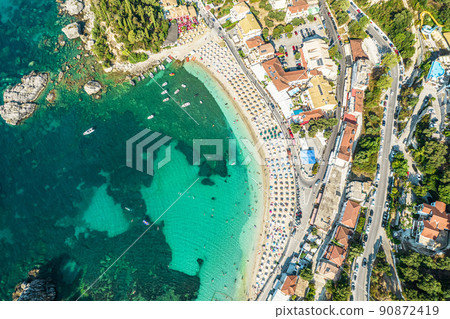 Beautiful colorful houses of seaside town, port of Parga with boats, cruise ship. Sand beach with umbrellas, tourist people, blue, turquoise sea water. Summer vacations and travel concept. Greece. 90872419