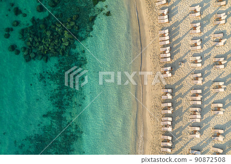 Aerial view of many white sunbed, lounge on sandy beach. Summer and travel concept. Blue, turquoise transparent water surface of ocean, sea, lagoon. Aerial, drone view Aerial view of many white sunbed, lounge on sandy beach. Summer and travel concept. Blue, turquoise transparent water surface of ocean, sea, lagoon. Aerial, drone view 90872508