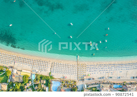 Beautiful colorful houses of seaside town of Parga with boats, cruise ship. Sand beach with umbrellas, tourist people, blue, turquoise sea water. Summer vacations and travel concept. Greece. Aerial, 90872541