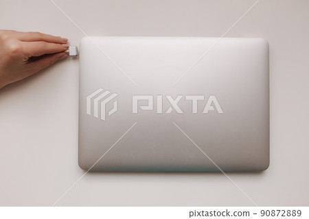 Top view of female hand holding the power plug of pc notebook. Laptop power 90872889