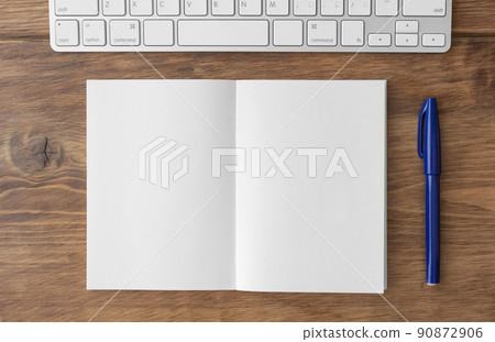 棕色木桌上的空白雙頁筆記本、鍵盤和藍筆 90872906