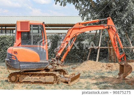 The orange mini backhoe stop in Construction site The orange mini backhoe stop in Construction site 90875275