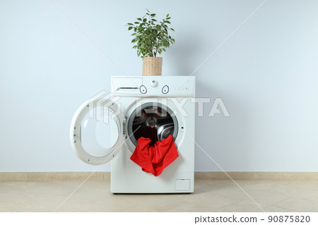 Concept of housework with washing machine against white wall 90875820