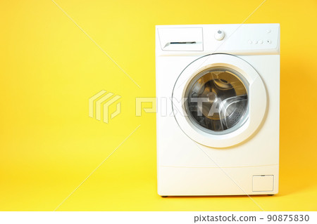 Modern white washing machine on yellow background 90875830