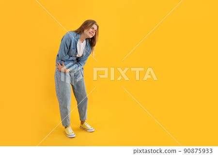 Girl with abdominal pain on yellow background Girl with abdominal pain on yellow background 90875933