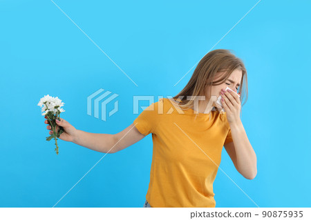 Girl with allergy hold flower on blue background Girl with allergy hold flower on blue background 90875935