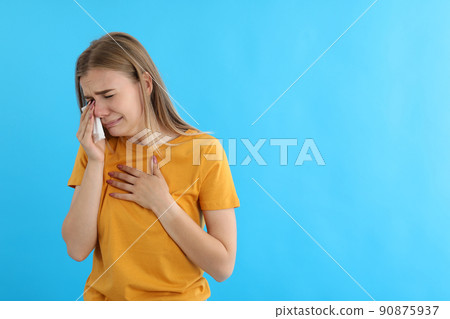 Crying girl in t-shirt on blue background Crying girl in t-shirt on blue background 90875937
