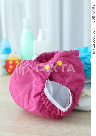 Concept of baby clothes with reusable diapers on gray textured table Concept of baby clothes with reusable diapers on gray textured table 90876492