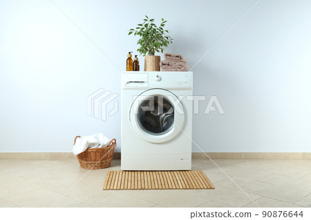 Concept of housework with washing machine against white wall 90876644