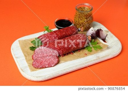 Concept of tasty food with salami sausage on mint background Concept of tasty food with salami sausage on mint background 90876854