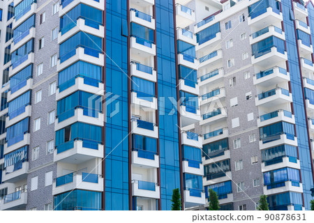 Abstract view of a multi-family residential complex of condominiums with window balconies painted in blue and white. 90878631