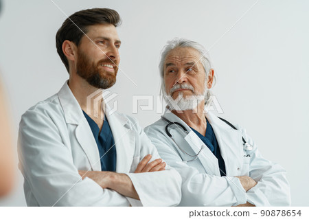 Two professional doctors in uniform standing in hospital with crossing arms 90878654