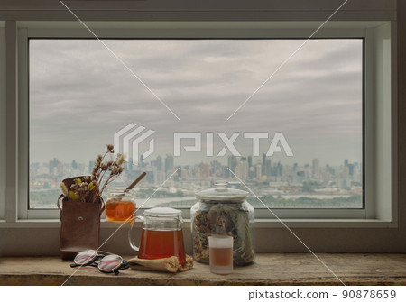 Refreshing with Chinese herbal tea (Jub Lieng) served with honey on old wooden table with city view. 90878659