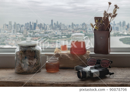 Refreshing with Chinese herbal tea (Jub Lieng) served with honey on old wooden table with city view. Refreshing with Chinese herbal tea (Jub Lieng) served with honey on old wooden table with city view. 90878706