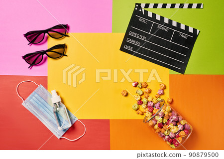 Tasty and colour popcorn, 3d glasses and movie clapper, protective mask on colorful background. Copy space 90879500