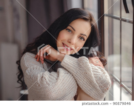Beautiful young woman near window at home Beautiful young woman near window at home 90879846