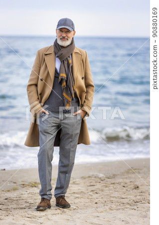 old man walking on the beach 90880169