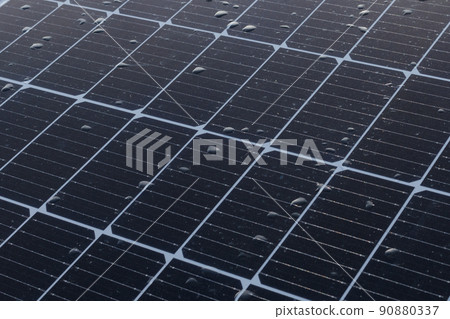 Solar panels on a construction site with raindrops on them Solar panels on a construction site with raindrops on them 90880337