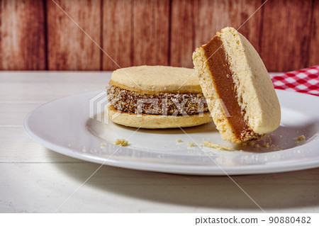 Argentine classic alfajores of cornstarch and dulce de leche with coconut on a vintage plate. Landscape Orientation. sweet snack Argentine classic alfajores of cornstarch and dulce de leche with coconut on a vintage plate. Landscape Orientation. sweet snack 90880482